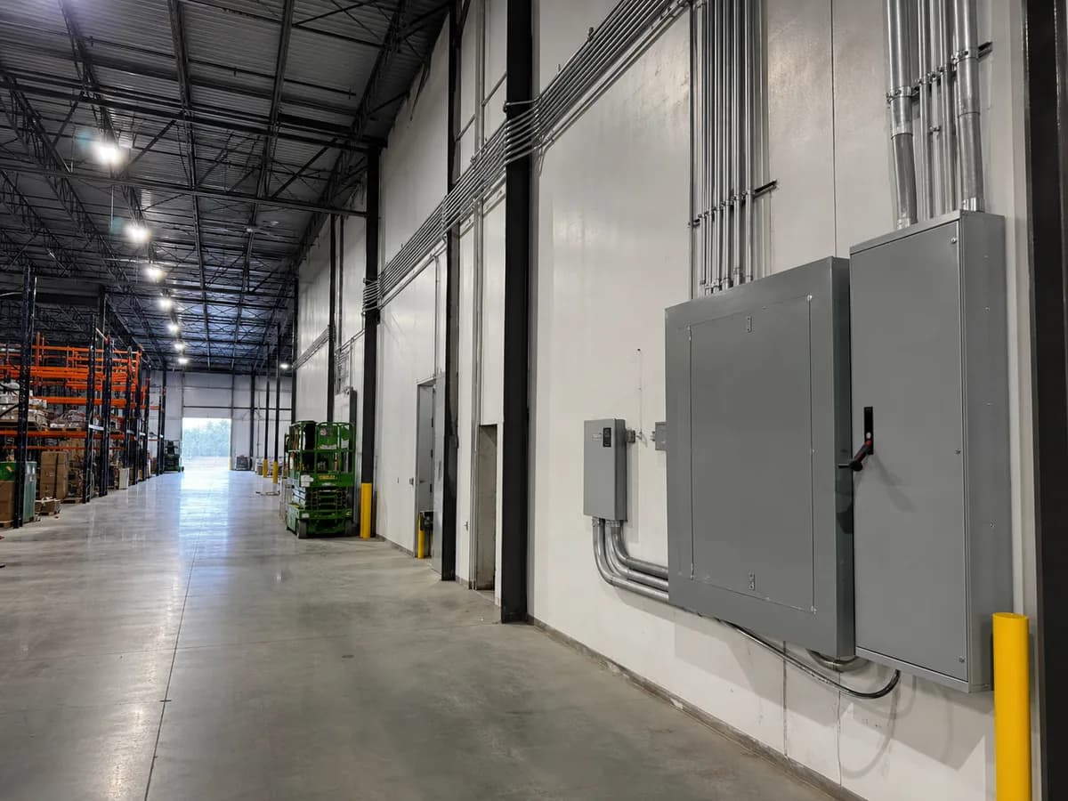 Warehouse electrical panels, conduit, high-bay lighting, and racking